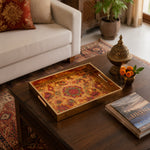 Diwali Paisley Mandala Tray with Diyas - Gold Frame - Minti Home displayed on a dining table with a porcelain teapot and fresh flowers, vintage cabinet in background.