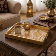 Islamic Geometric Gold Decorative Tray with Crescent Medallions | Minti Home displayed on a dining table with a porcelain teapot and fresh flowers, vintage cabinet in background.